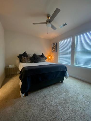 1 dormitorio con 1 cama y ventilador de techo en Luxury Comfy Townhome, en Charlotte