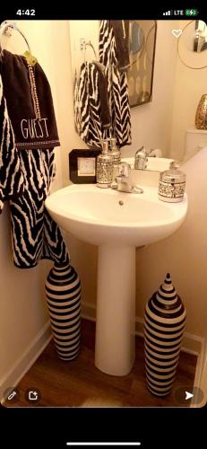 baño con lavabo blanco y toalla blanca y negra en Luxury Comfy Townhome, en Charlotte