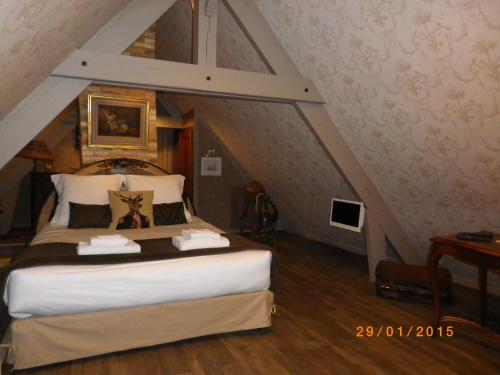 a bedroom with a large bed in a attic at Chambres et Table d'Hôtes Les Machetières in Langeais