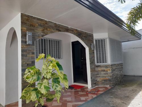 a house with a brick wall and a black door at Silay DennisFhin Residence in Silay