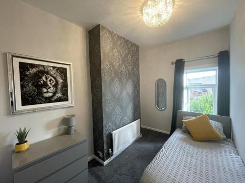 1 dormitorio con 1 cama y una foto en la pared en Moda House Wigan - Beautiful 4 Bed Property en Pemberton