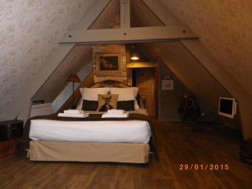 a bedroom with a large bed in a attic at Chambres et Table d'Hôtes Les Machetières in Langeais