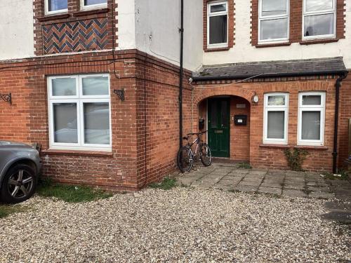 ein Backsteinhaus mit einem Fahrrad davor in der Unterkunft Two Bedroom, Off-road Parking in Ludgershall