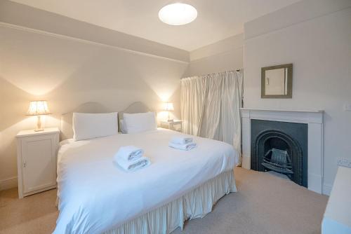 ein Schlafzimmer mit einem weißen Bett mit zwei Handtüchern darauf in der Unterkunft 18 Hartington, Aldeburgh in Aldeburgh