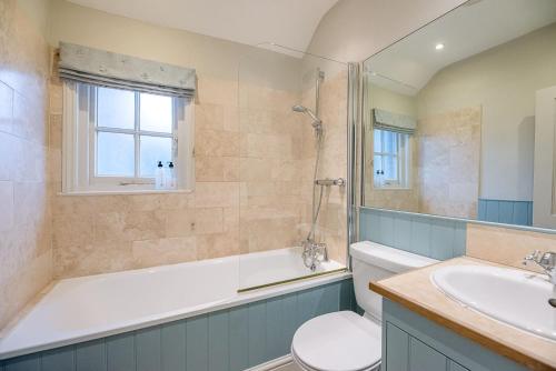 ein Badezimmer mit einer Badewanne, einem WC und einem Waschbecken in der Unterkunft 18 Hartington, Aldeburgh in Aldeburgh