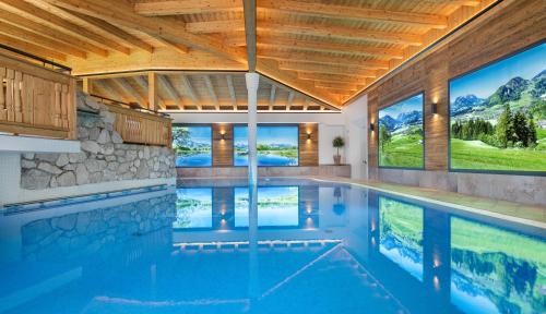 a swimming pool in a house with a mountain view at Hotel Alpina Wellness & Spa Resort in Kössen