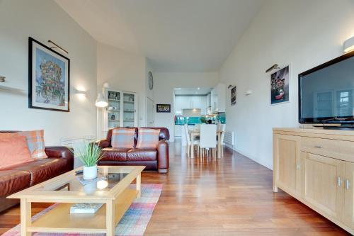 a living room with a couch and a flat screen tv at Crown Apartments 3B Ideal Choice for City Breaks in Newcastle upon Tyne