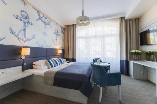 um quarto de hotel com uma cama e uma cadeira em H Villa Herkules em Świnoujście