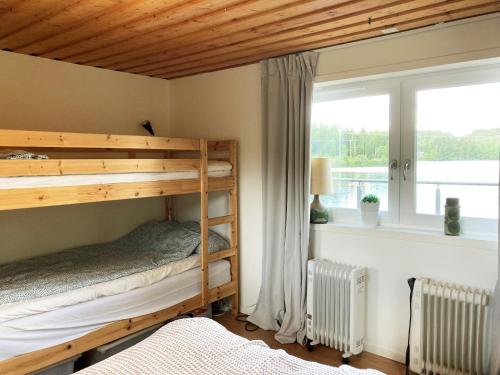 een slaapkamer met 2 stapelbedden en een raam bij Lovely cottage in Bankeryd with a panoramic view of the lake in Bankeryd