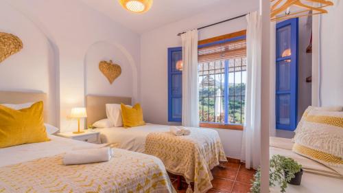 een slaapkamer met 2 bedden en een raam bij Villa Cortijo Miramar Frigiliana by Ruralidays in Frigiliana