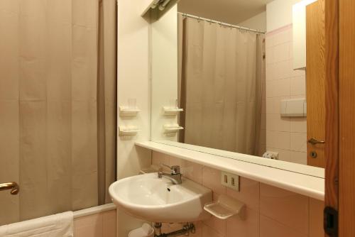 a bathroom with a sink and a mirror at Residence Hotel Casa Metz in Santa Cristina Gherdëina