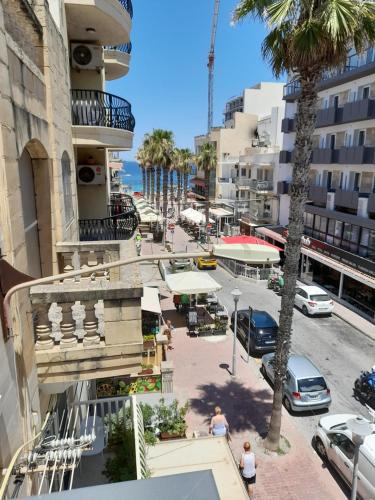 una calle en una ciudad con palmeras y edificios en Seabreeze Holiday Guestrooms, en St Paul's Bay
