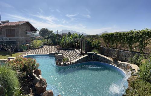 a swimming pool in a yard with a patio at SaffronStays Lake House Bouganvillea, Nashik - rustic pool villa with great lake views and patio dining in Nashik