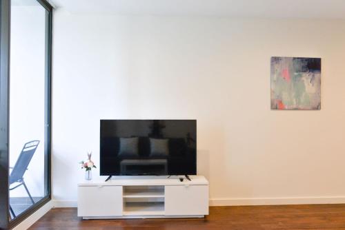 a living room with a tv on a white cabinet at Sydney CBD Modern 2 bedroom Apartment in Sydney
