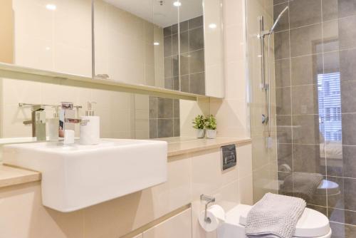 y baño blanco con lavabo y ducha. en Sydney CBD Modern 2 bedroom Apartment en Sídney