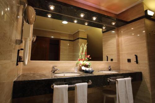 baño con 2 lavabos y espejo grande en Hotel Conde Ansúrez, en Valladolid