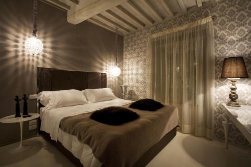 a bedroom with a large bed and a lamp at Palazzo Bontadosi Hotel & Spa in Montefalco