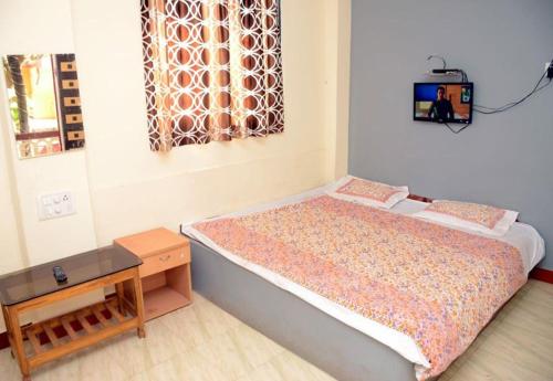 een slaapkamer met een bed met een tafel en een raam bij Sai Sagar Beach Niwas in Malvan