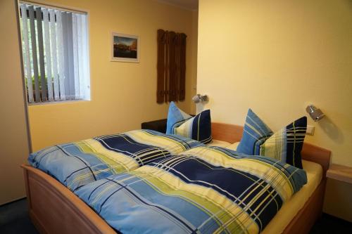 a bed with a blue and yellow comforter in a bedroom at Ferienwohnung Splitek in Kurort Altenberg