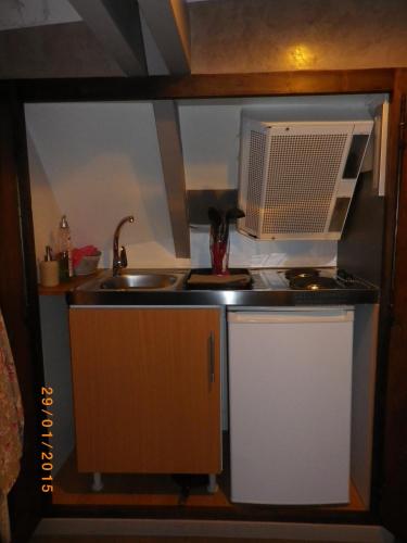 a small kitchen with a sink and a microwave at Chambres et Table d'Hôtes Les Machetières in Langeais