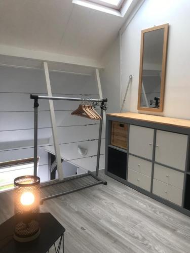 Cette chambre comprend une table, un miroir et une étagère. dans l'établissement jolie studio centre ville d'arras, à Arras