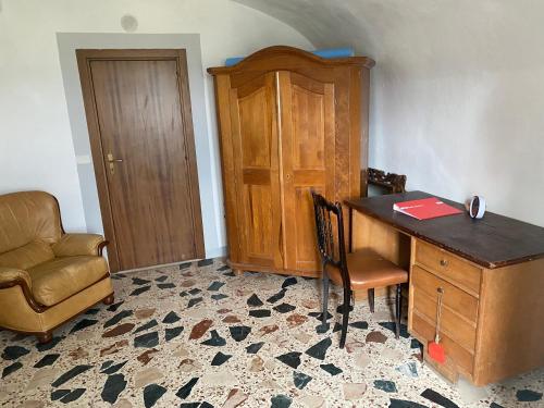 ein Büro mit einem Schreibtisch, einem Stuhl, einem Tisch und einem Stuhl in der Unterkunft Casa al vecchio mulino in Sperlinga