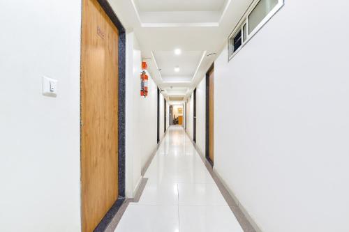 an empty corridor in an office building with a wooden door at FabHotel Crystal - Nr Odau Ring Road in Ahmedabad