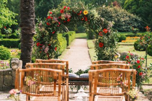 an outdoor table with an arch with flowers and chairs at Palacio de Aviles Affiliated By Melia in Avilés