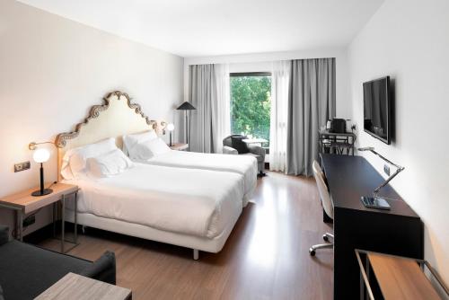 una camera d'albergo con un grande letto bianco e una scrivania di Palacio de Aviles Affiliated By Melia ad Avilés
