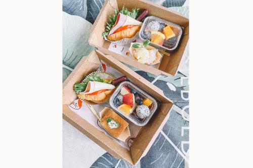 two boxes filled with different types of sushi at Sleepy House Chiang Rai in Chiang Rai