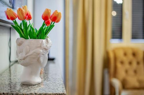 a vase with red tulips in it sitting on a table at Viogor Apartmani Prestige Forest Zlatibor in Zlatibor
