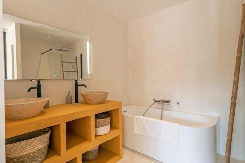 une salle de bain avec un lavabo, un miroir et une baignoire dans l'établissement Villa Renajolo 10 pers piscine chauffée 2 min plage en voiture, à Sainte-Lucie de Porto-Vecchio