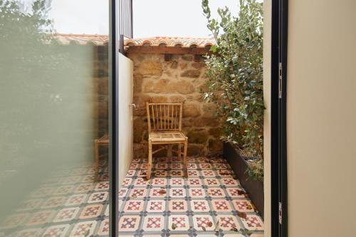 a chair sitting on a patio outside a door at THE PINTA Boutique in Armamar