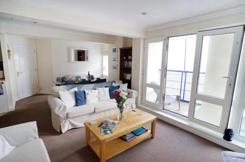 ein Wohnzimmer mit einem weißen Sofa und einem Tisch in der Unterkunft The View, Sandown in Sandown