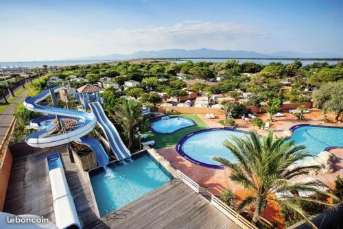 - une vue aérienne sur un parc aquatique avec 2 toboggans dans l'établissement Mobile Home La Roulotte Catalane, à Canet