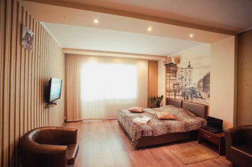 a bedroom with a bed and a large window at Molex Apartments in Chernihiv