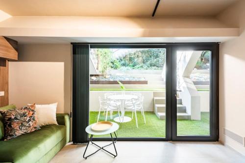 a living room with a green couch and a table at LagoC0C00N - Colazione - 300m stazione - 800m lago in Desenzano del Garda