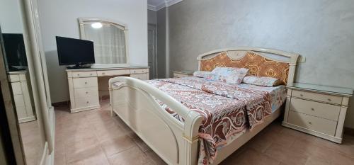 sypialnia z łóżkiem i telewizorem w obiekcie Comfy 2-Bedrooms Apartment in Cairo 44-2 w Kairze