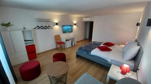 um pequeno quarto com uma cama, uma mesa e cadeiras em Amaryllis residence, apartment Diana & Deluxe rooms with shared kitchen em Veli Lošinj