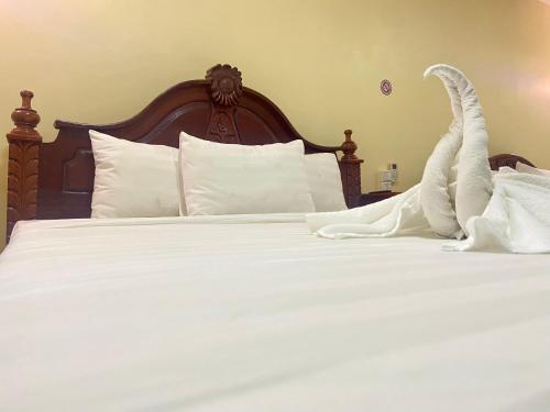 a bed with white sheets and white pillows at Savet Guesthouse in Stœ̆ng Trêng