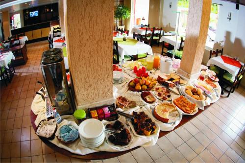 Hotel Bartz في كاماكوا: طاولة مليئة بالطعام على طاولة في مطعم