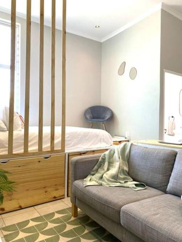 a living room with a bed and a couch at Beachside Studio Apartment on Surfers Corner in Cape Town