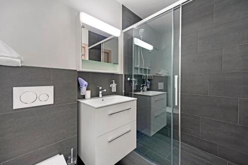 a bathroom with a white sink and a shower at Abitaziun Belmunt 103 - St Moritz "LOGA ELEGANCE APARTMENT" in St. Moritz