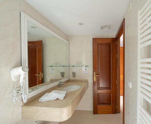 a bathroom with a sink and a large mirror at Apartamentos Los Tilos in Paguera