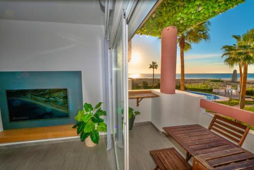 einen Balkon mit einer Bank und Meerblick in der Unterkunft Apartasuites Royal Zahara, Máximo confort con vistas al mar in Zahara de los Atunes