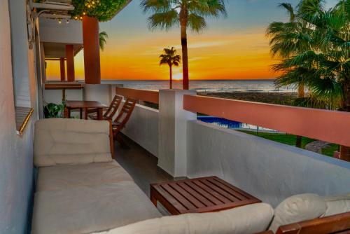 Apartasuites Royal Zahara, Máximo confort con vistas al mar في ساهارا ذي لوس أتونِس: شرفة مع أريكة وإطلالة على المحيط