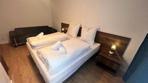 - une chambre avec un lit doté de draps et d'oreillers blancs dans l'établissement Taverne & Pension Lubenbachtal, à Zella-Mehlis