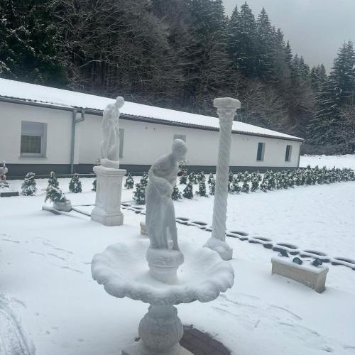 deux statues dans une cour recouverte de neige dans l'établissement Taverne & Pension Lubenbachtal, à Zella-Mehlis
