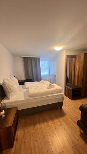 Cama grande en habitación con suelo de madera en Taverne & Pension Lubenbachtal, en Zella-Mehlis