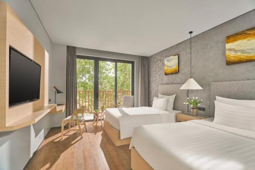 a hotel room with two beds and a television at The Secret Con Dao in Con Dao